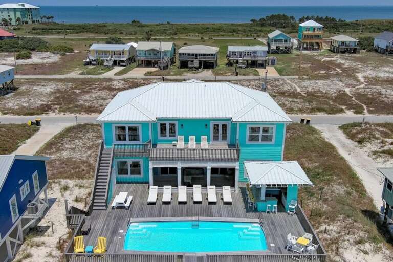 Pastel-blue Beachside Building With Pool, Perched Precariously Near Pristine Sands