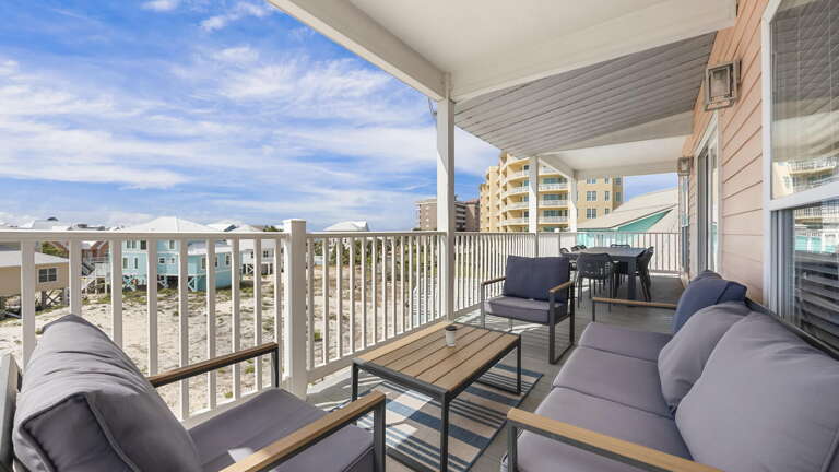 Balcony View Of A Beachside Building, Featuring Furniture And Fencing