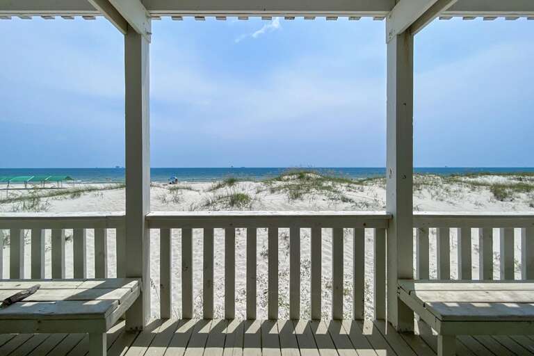 Beachside Balcony View With White Sands Stretching To Turquoise Waters