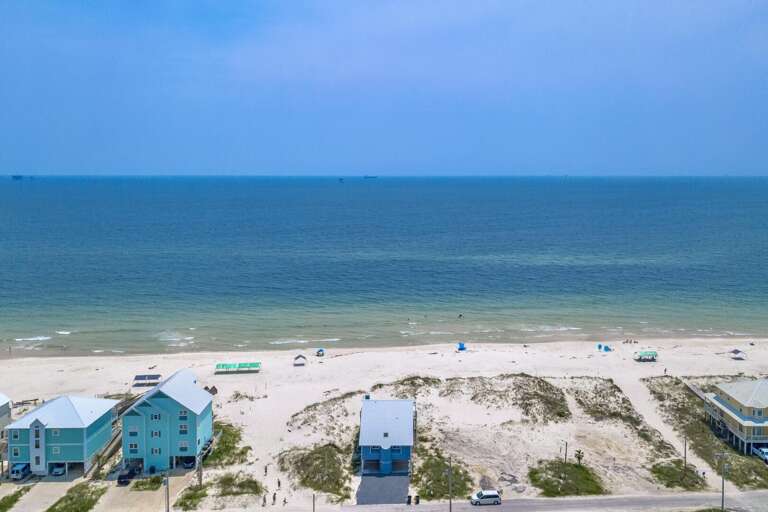 Beachfront Buildings Beside Blue Sea And Sandy Shore