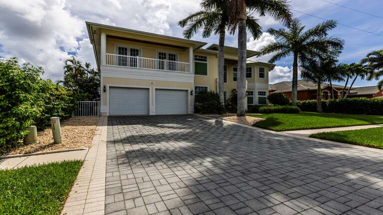 Two-story House With Palm Trees And Driveway