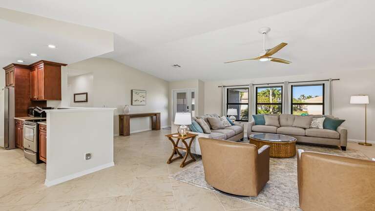 Spacious Living Space With Seating, Ceiling Fans, And Scenic Windows