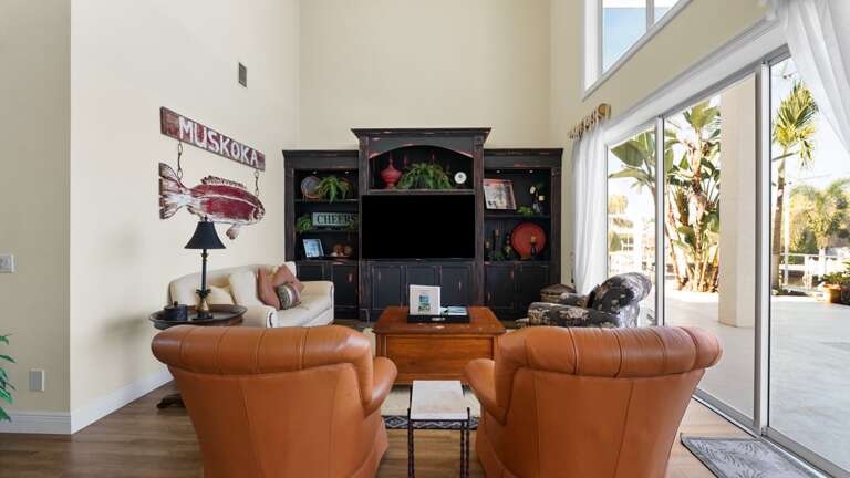 Living Room With Leather Chairs, Black Shelving, Sliding Glass Doors