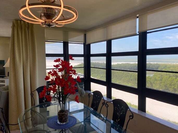 Interior View Of A Vacation Rental Dining Area With Glass Table And Scenic View From Window